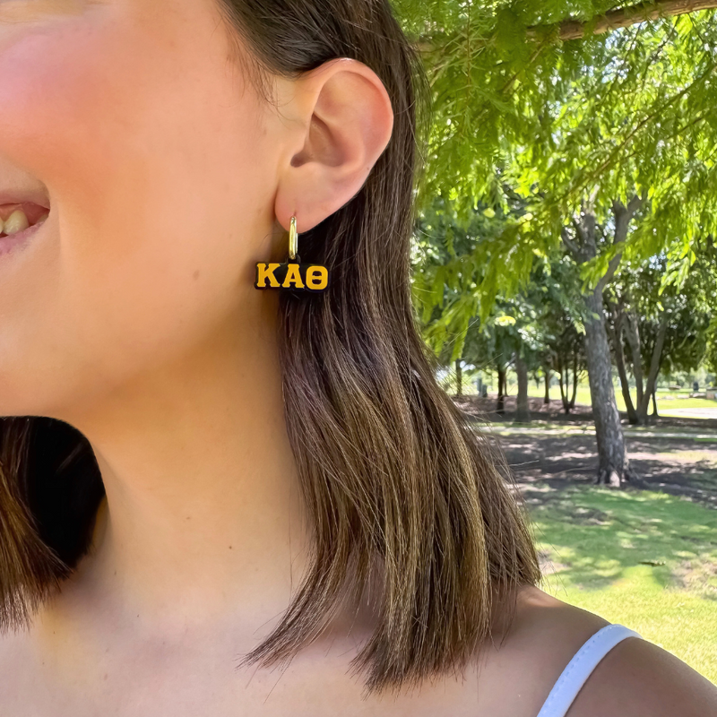 Wear your letters. Live your legacy. Love your style.

Add a little charm to your everyday look with our Kappa Alpha Theta Charmed Life Huggies!&nbsp;Featuring your Greek Letters in a bold yet dainty way, these lightweight huggie hoops are perfect for every moment, and made to celebrate your chapter all semester long.