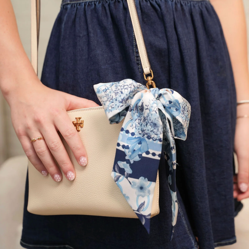 Wrap yourself in a playful, yet iconic one-of-a-kind piece in our silky scarflette! Vibrant blue and white florals dance alongside whimsical illustrations with hits of navy.&nbsp; This luxurious accessory captures the charm and heritage of Chapel Hill in every thread – perfect for locals and admirers of elegance alike. A wearable celebration of this historic community's unique character!