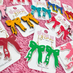 Add the perfect finishing touch to your Bid Day look with our Bid Day Bow Earrings! These bold, lightweight bows are designed to show off your chapter spirit with style and sparkle. Pair them with your favorite Bid Day fit for a look that's full of fun and sisterhood pride!
