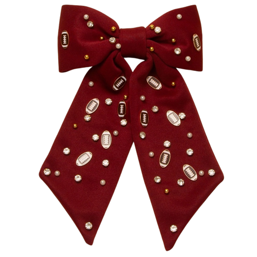 Bring a burst of team pride to any look with our Football Charm Game Day Hair Bow. Bright, bold, and full of school spirit, this eye-catching accessory has beautiful beading details with enamel football charms. Lightweight and versatile, it’s the perfect finishing touch for showing off your colors—on game day and beyond.