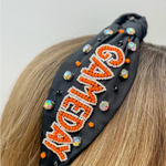 Our NEW rhinestone be-jeweled "Game Day" headbands, feature a trendy knotted design and are adorned with sparkling rhinestones and dual colored beads arranged in a playful "Gameday" pattern.  This headband is perfect for showing off your team spirit at sporting events, tailgates, or any other gameday celebration. 