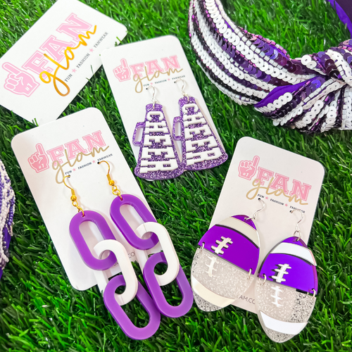 There's no better time to accessorize your Game Day look.  Get GLAM ready with us in our new Glitter Glam Purple/White Collection.  Available in three collectable styles.