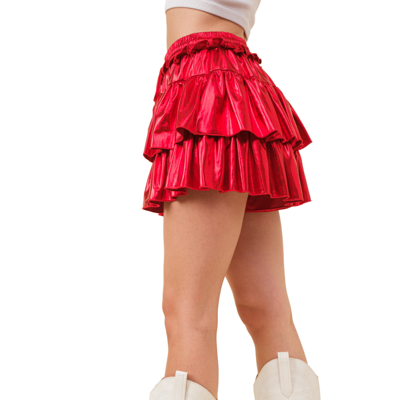 Our Metallic Skort is here to steal the spotlight in orange, purple, or red!&nbsp;With a flirty fit, fierce shine, and built-in shorts for all-day comfort, it's made for dancing, cheering, and being the most extra in the stands. Pair it with your fave tee and let the glam do the talking!