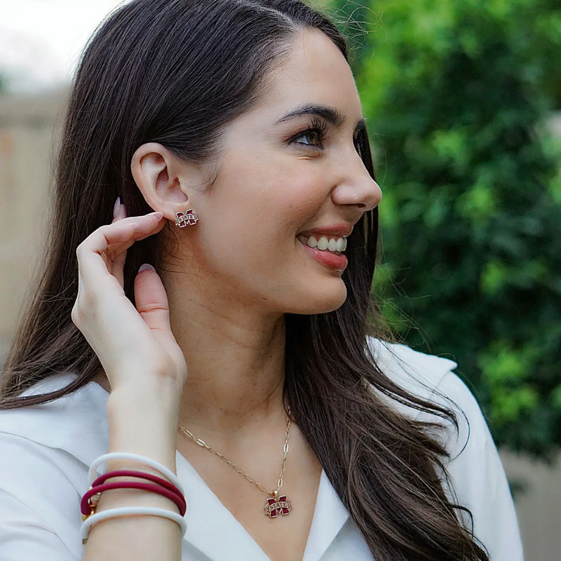 Add a splash of maroon and white to your look with these vibrant enamel Mississippi State Bulldogs stud earrings! Featuring the iconic logo, they’re the perfect way to show your team spirit — whether you’re ringing your cowbell at Davis Wade Stadium or repping the Bulldogs every day. Lightweight, fun, and full of flair, these earrings are small but mighty — just like your game-day energy!