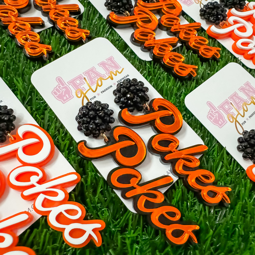 Let's Go Pokes!&nbsp; It's Game Day in Stilly and we're ready to cheer on our Cowboys in style! Get game day GLAM in our new cursive Pokes dangles.&nbsp; Available in two collectable colors they are the perfect add-on to your Game Day ensemble.