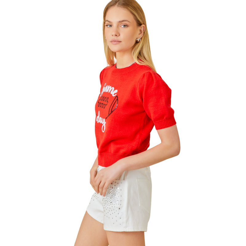Our red Game Day Puff Sleeve Sweater Top is a total win for your game day lineup. Featuring bold embroidered "Game Day" lettering and a front-and-center football graphic, this vibrant knit brings the hype. Puff sleeves add a playful, girly edge, while the standout red color makes sure all eyes are on you—from the lot to the stands.