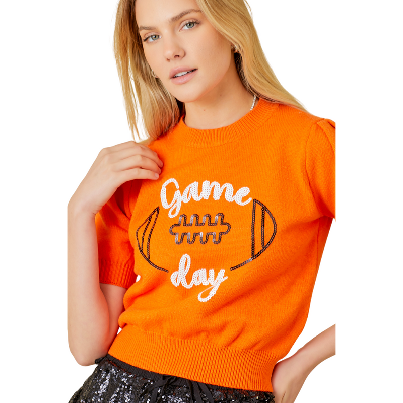 Our Orange Game Day Puff Sleeve Sweater Top is a total win for your gameday lineup. Featuring bold embroidered "Game Day" lettering and a front-and-center football graphic, this vibrant knit brings the hype. Puff sleeves add a playful, girly edge, while the standout orange color makes sure all eyes are on you—from the lot to the stands.