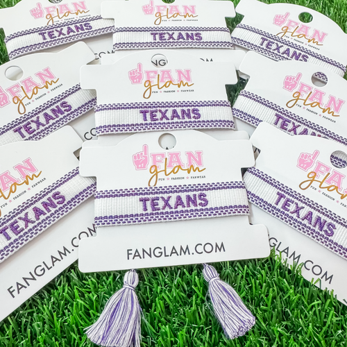 Bleed Purple and Stand Tall wearing our Tarleton Texans Tassel Bracelet! Featuring a metallic TEXANS embroidery on a chic purple and white woven band, this adjustable bracelet is perfect for game days, tailgates, and showing off your Texan pride.

With stylish tassel accents, it’s the perfect accessory for any true Tarleton State fan. Go Texans!