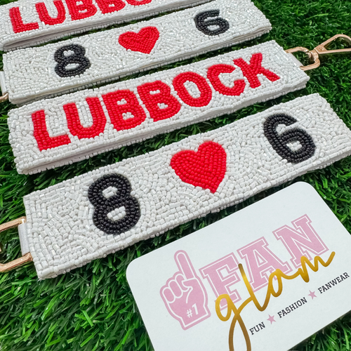 Show off your Lubbock pride with our exclusive fun, beaded wristlet key chain. Easy to wear on your wrist or clip to your keys or back pack, it keeps your essentials close while adding a pop of school spirit to any outfit. Perfect for game days or everyday adventures!

Featuring a secure classic gold clasp closure.