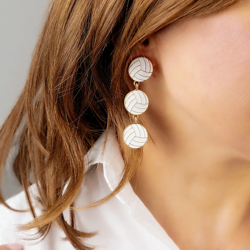 Spike your style game with these triple-drop volleyball earrings! With sleek enamel detailing and a chic gold trim, they’re perfect for volleyball lovers who want to show their passion with every outfit. Light, bold, and ready to shine — whether you’re at the game, out with friends, or just serving up everyday glam. Because why settle for basic when you can bump, set, and slay?