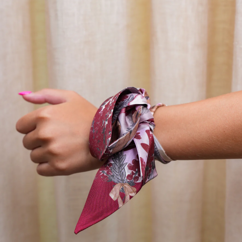 This vibrant scarflette is full of College Station charm and a whole lotta Aggie spirit! Featuring delicate florals in bold maroon and soft blush, it's sprinkled with playful pup silhouettes — a sweet nod to everyone's favorite mascot. Whether you're walking campus, heading to Kyle Field, or brunching on Northgate, this silky stunner is your new game day (and every day) essential.