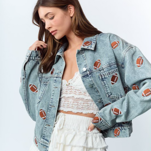 Get ready to steal the spotlight this tailgate season with the Friday Night Lights Football Embroidered Denim Jacket. Its light wash and relaxed, slightly oversized fit make it perfect for layering on cool fall evenings. Fully covered in playful football embroidery, it adds a fun, sporty vibe to any look. Whether layered over your favorite tees, dresses, or team colors, this jacket is your go-to for game day style and comfort.