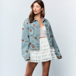 Get ready to steal the spotlight this tailgate season with the Friday Night Lights Football Embroidered Denim Jacket. Its light wash and relaxed, slightly oversized fit make it perfect for layering on cool fall evenings. Fully covered in playful football embroidery, it adds a fun, sporty vibe to any look. Whether layered over your favorite tees, dresses, or team colors, this jacket is your go-to for game day style and comfort.