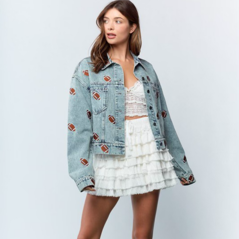 Get ready to steal the spotlight this tailgate season with the Friday Night Lights Football Embroidered Denim Jacket. Its light wash and relaxed, slightly oversized fit make it perfect for layering on cool fall evenings. Fully covered in playful football embroidery, it adds a fun, sporty vibe to any look. Whether layered over your favorite tees, dresses, or team colors, this jacket is your go-to for game day style and comfort.