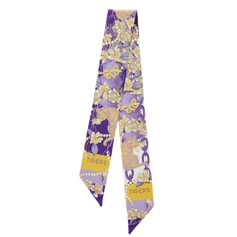 Geaux glam, Tiger style! This LSU-inspired scarflette is loud, proud, and full of Southern sparkle! Featuring a chic floral print in purple and gold with playful tiger silhouettes woven throughout, it's the perfect mix of fierce and feminine. Whether you're tailgating in Baton Rouge, walking to class on campus, or chanting Geaux Tigers! at the top of your lungs, this silky stunner brings big LSU energy to any outfit.
