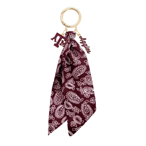 Bring the fun wherever you go with this game day-ready bag charm! Featuring a bold paisley-print bandana, shiny gold hardware, and sporty charm accents, it’s the ultimate way to show your spirit in style. Clip it to your bag, keys, or backpack and let the tailgate vibes follow you everywhere. Perfect for cheering, repping your team, or just adding a pop of personality to your look!