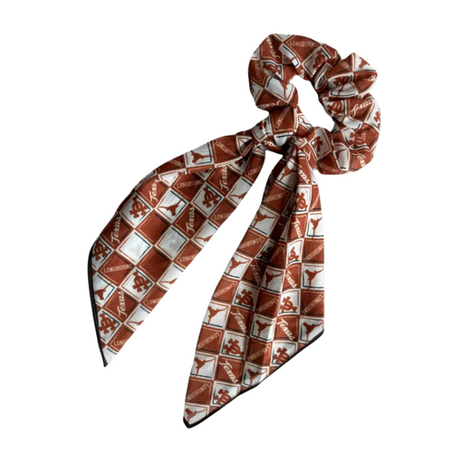 Give your hair a playful upgrade with the Texas Longhorns Scarf Scrunchy. Made from soft, lightweight fabric, it features attached scarf-style tails that add a fun, effortless flair to any look. Perfect for showing off your Longhorn pride while keeping your style fresh and pulled together.