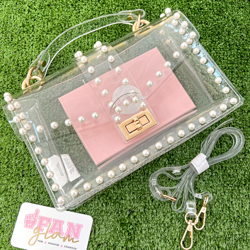 Our GameDay stadium compliant crossbody fashion bags are here! Featuring a clear PVC body with your choice of sparkling gold rhinestones, pearls or heavy metal grommet accents.  The main compartment is roomy and firmly structured including a turn lock closure for securing your personal items safely within. 