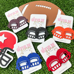 Show your love for the game when accessorizing your Game Day look with our team colored football helmet dangle earrings!   The perfect accessory to coordinate with your Friday Night Lights ensemble or Saturday tailgate style.