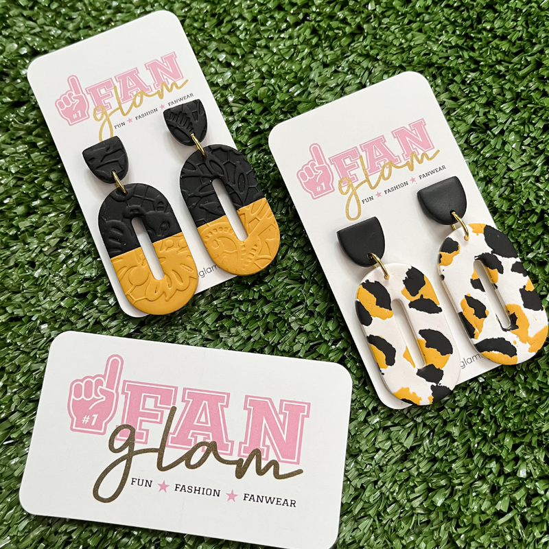 Our GameDay Tam Clay Co Black + Gold Jana Collection features two fun collectable styles, it's the perfect way to add team color and a fun pop of print to your gameday attire.