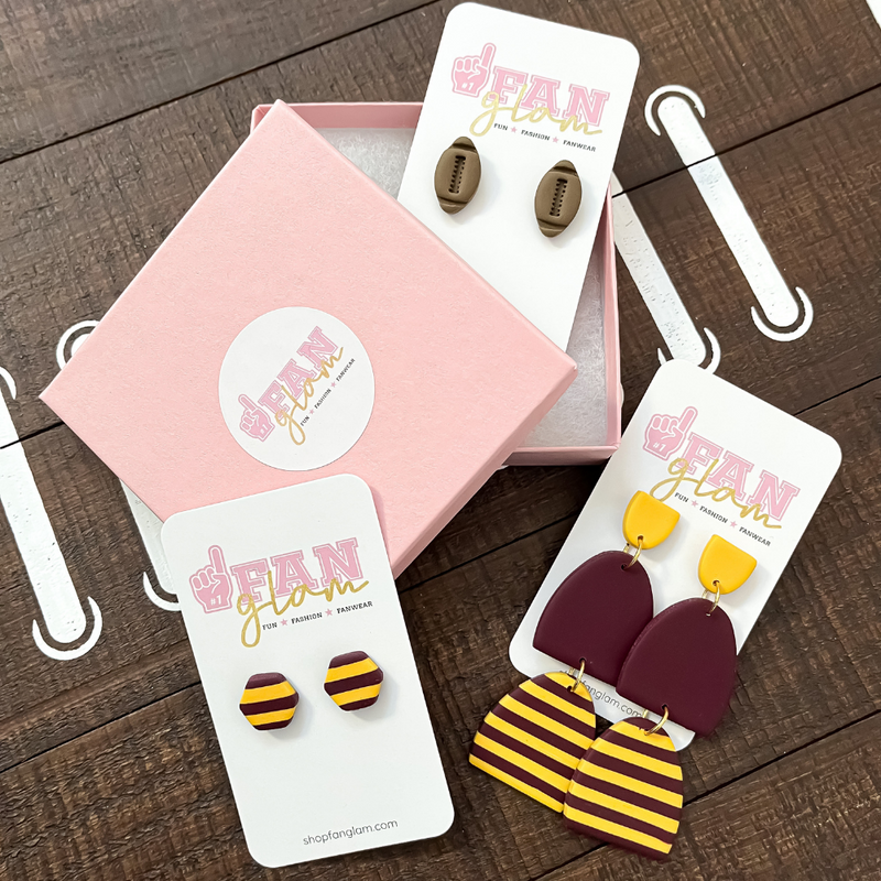 Our GameDay Tam Clay Co Maroon & Gold Collection features three fun collectable styles.  With custom team colors and sporty stripes these one-of-a-kind clay designs will add some print and pizzazz to your Game Day attire.