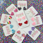 Love Is In The Air...  And our Glitter Glam Mini Heart Studs are the perfect pop of color + glam to help spread love to all your favorite humans this Valentine's!  A perfect gift for your bestie or your little one, its a versatile size that all ages can enjoy!  Super lightweight and comfortable, you will forget you have them on. Available in over a dozen fun colors, collect them all!