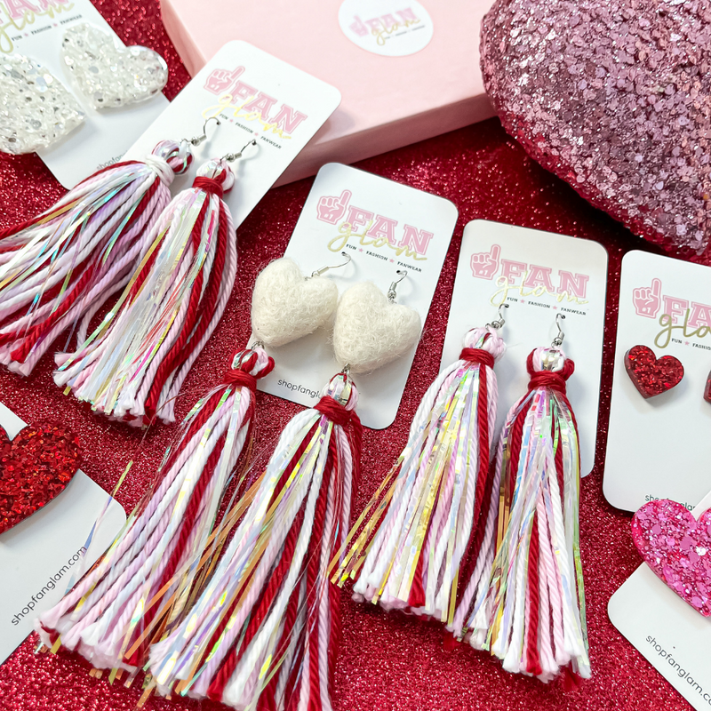 Let's give a BIG Shout Out to our Newest Arrival, our Valentine's Tinsel Pom Pom Fringe Earrings!! The perfect pop of color for Valentine's and a great way to add some festive flare to your game day attire!
